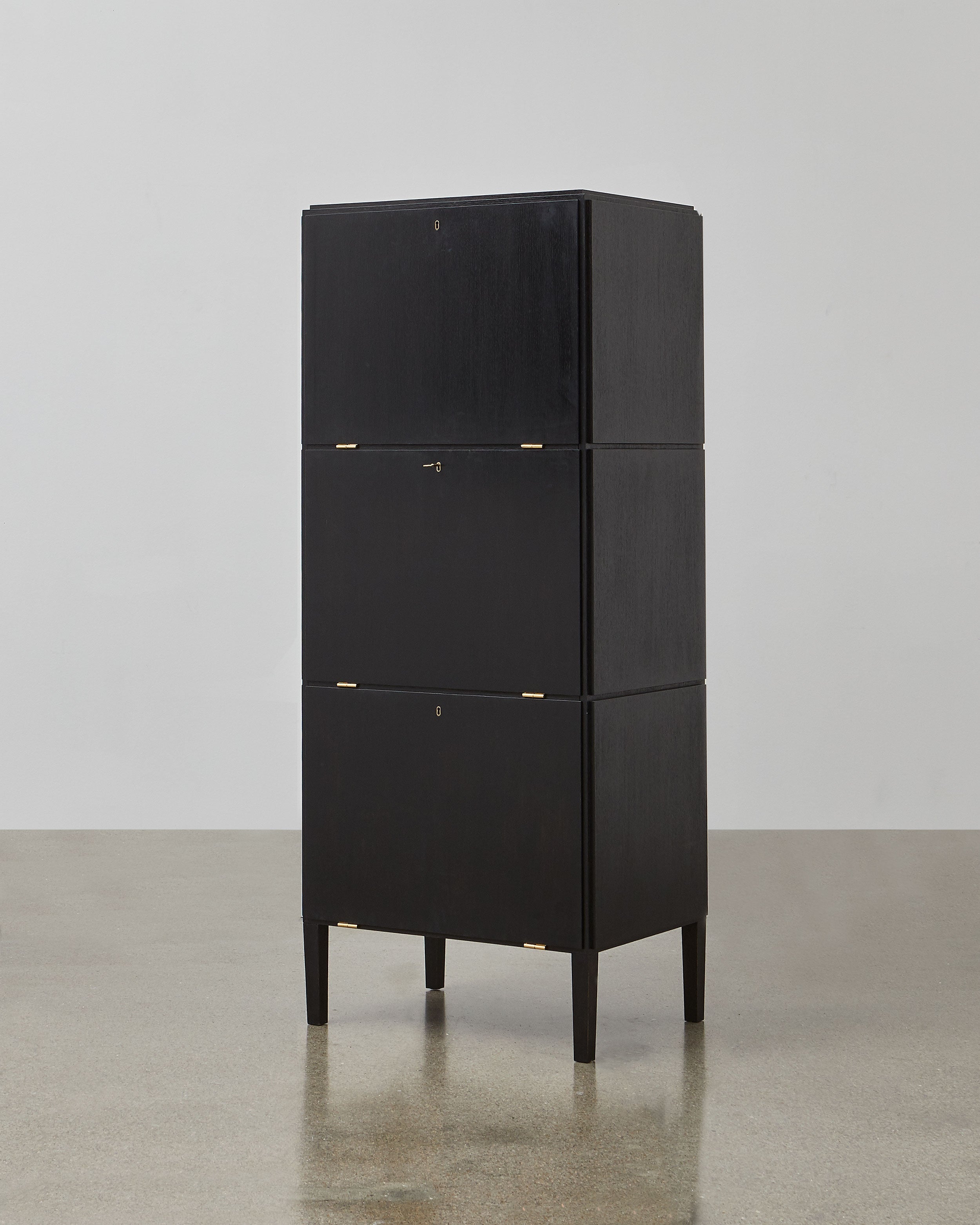 PH Cabinet by Poul Henningsen, Danish design classic (1930s)
A black wooden storage cabinet with three concealed compartments and gold-colored accents.