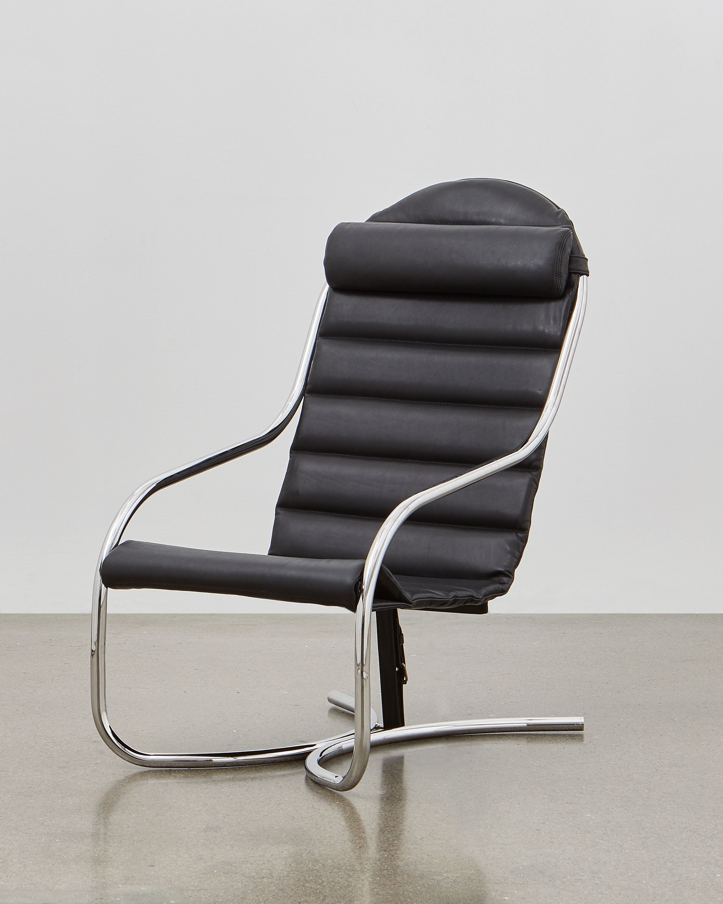 A black upholstered PH lounge chair with a chromed steel tube frame, designed by Poul Henningsen.