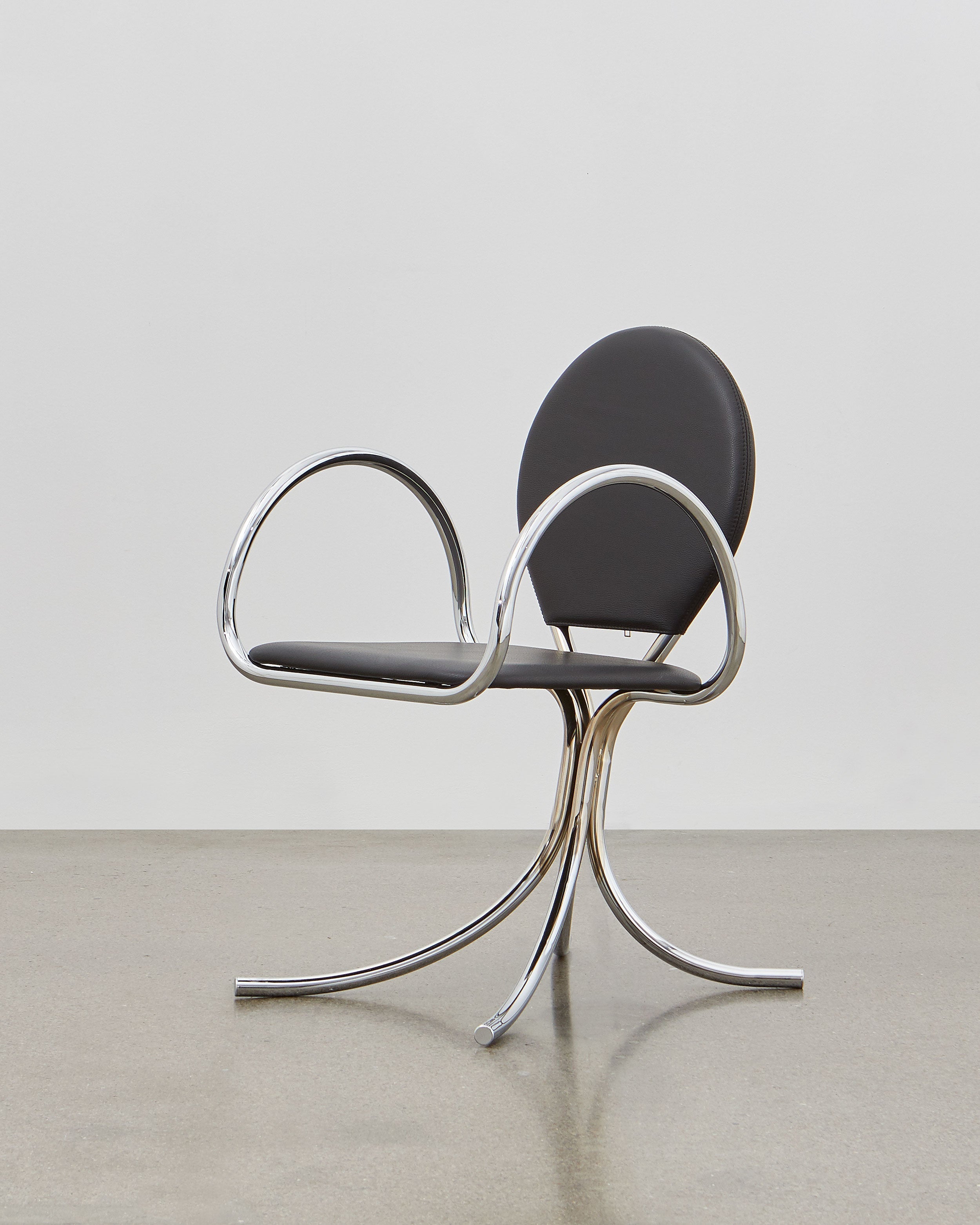PH Arm Chair by Poul Henningsen, Danish design classic (1932), A armchair with a black cushioned seat and backrest, and chrome steel tube frame.