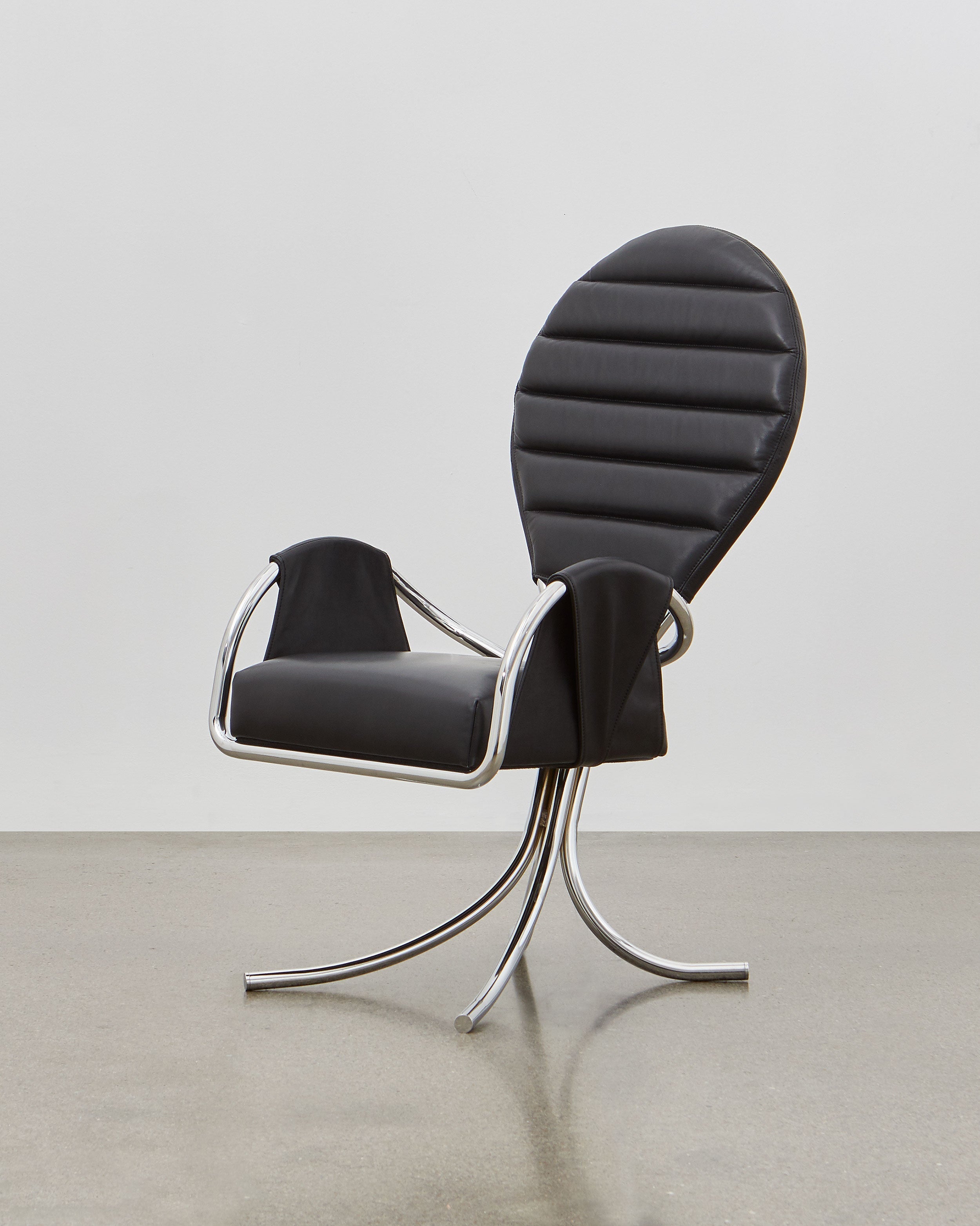 A black leather upholstered chair with a chrome-plated steel frame and a rounded backrest, designed in a modernist style.