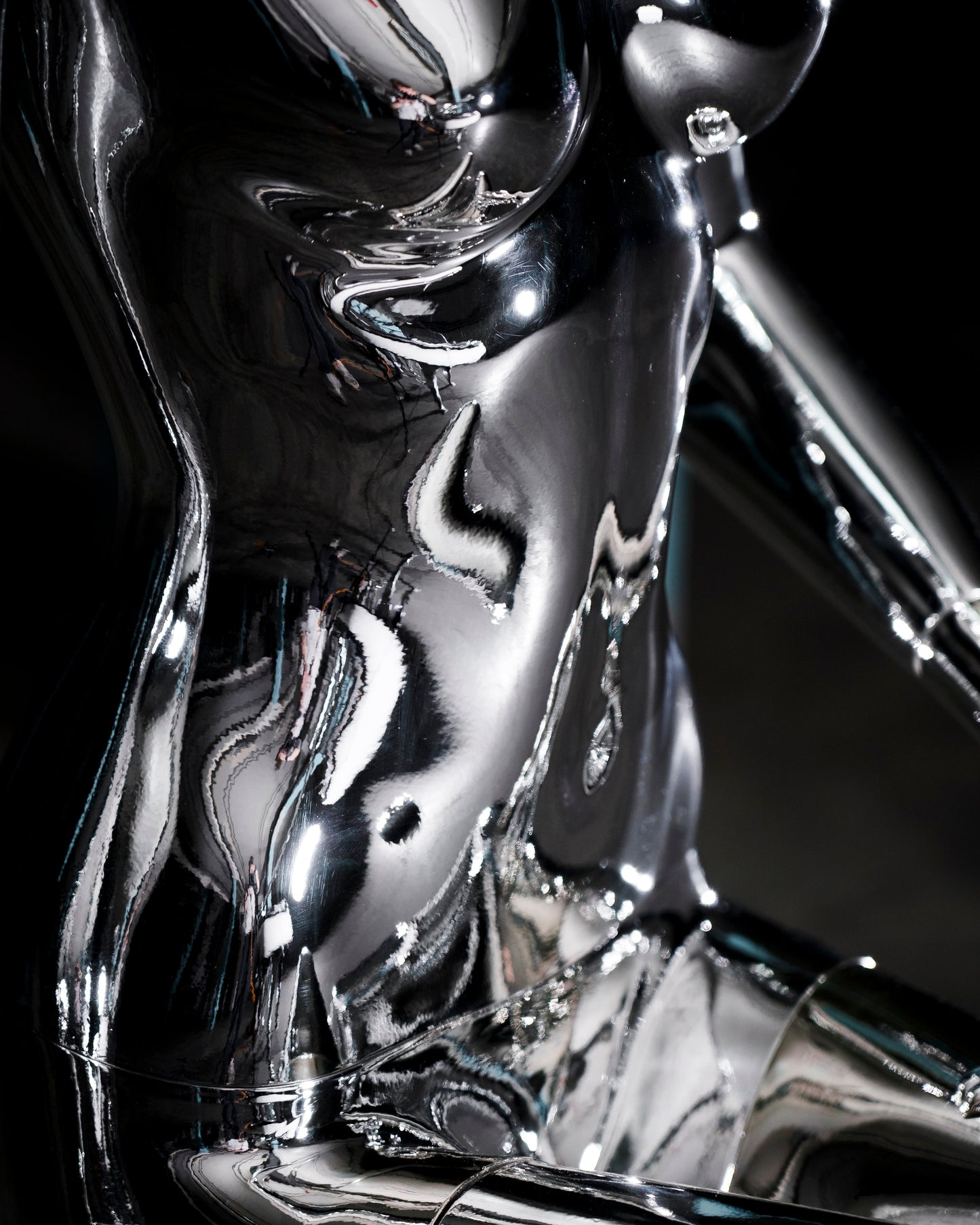 Audiomus is a audio design a chrome metallic sculpture of a seated figure on a concrete base with build in subwoofer and a mouth-blown glass sphere with light and the speaker driver built in 
