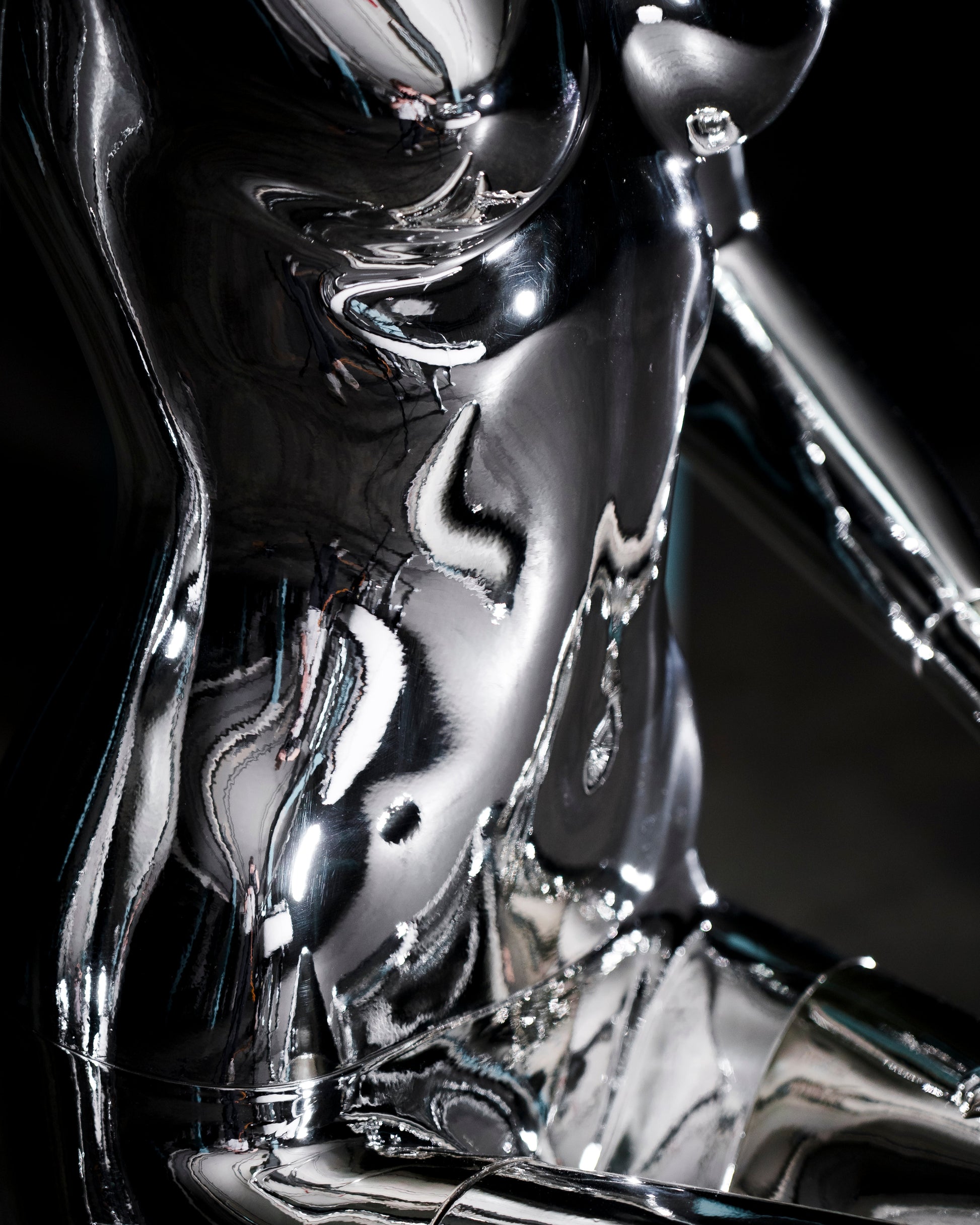 Audiomus is a audio design a chrome metallic sculpture of a seated figure on a concrete base with build in subwoofer and a mouth-blown glass sphere with light and the speaker driver built in 
