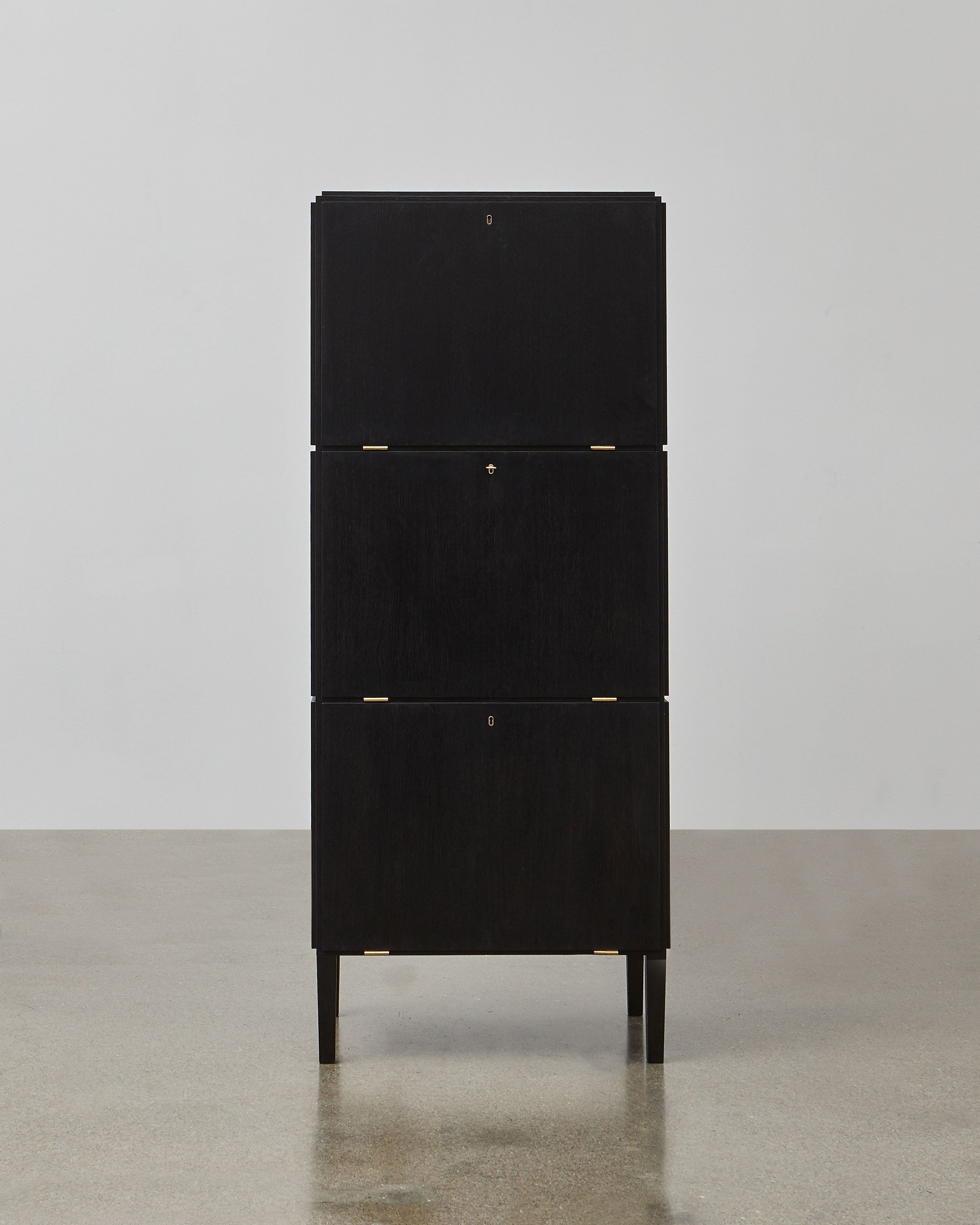 PH Cabinet by Poul Henningsen, Danish design classic (1930s)
A black wooden storage cabinet with three concealed compartments and gold-colored accents.