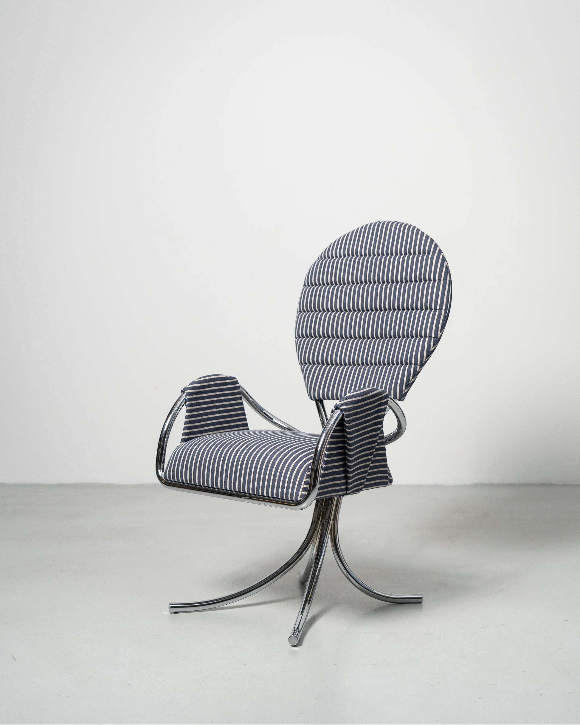 A wool upholstered chair with a chrome-plated steel frame and a rounded backrest, designed in a modernist style.