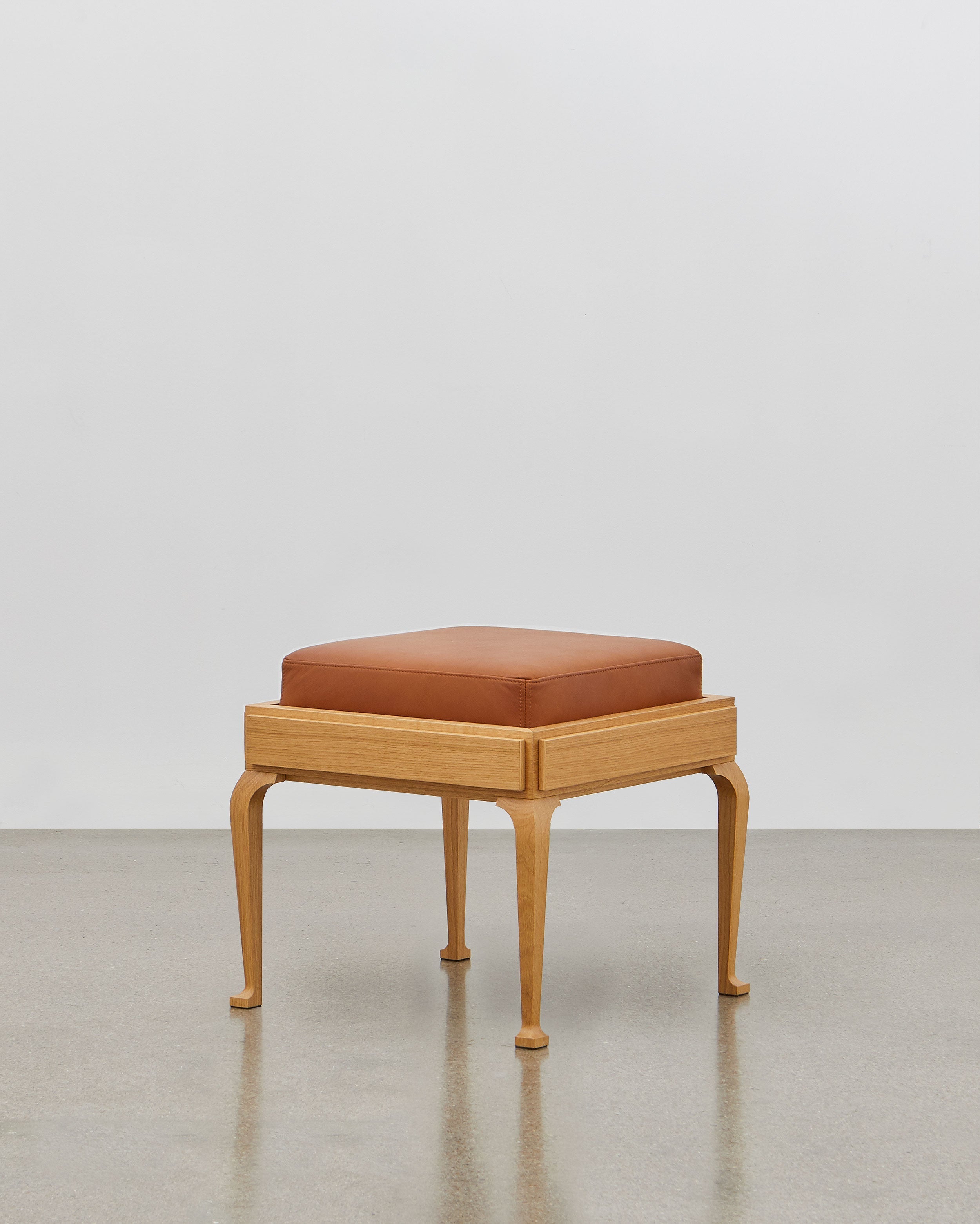 PH Stool by Poul Henningsen, Danish design classic (1920) A walnut upholstered stool standing on four angled wooden legs.