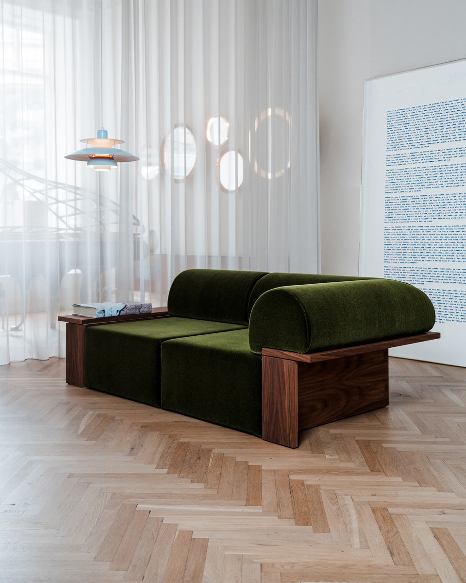 Wittorin Sofa Designed by Caisa Leifsdotter, Scandinavian design A solid-wood base frames a generous seat; movable arm and back cushions support both corner and straight layouts. The wooden surround doubles as a low table surface for lamps, books or a tray.
