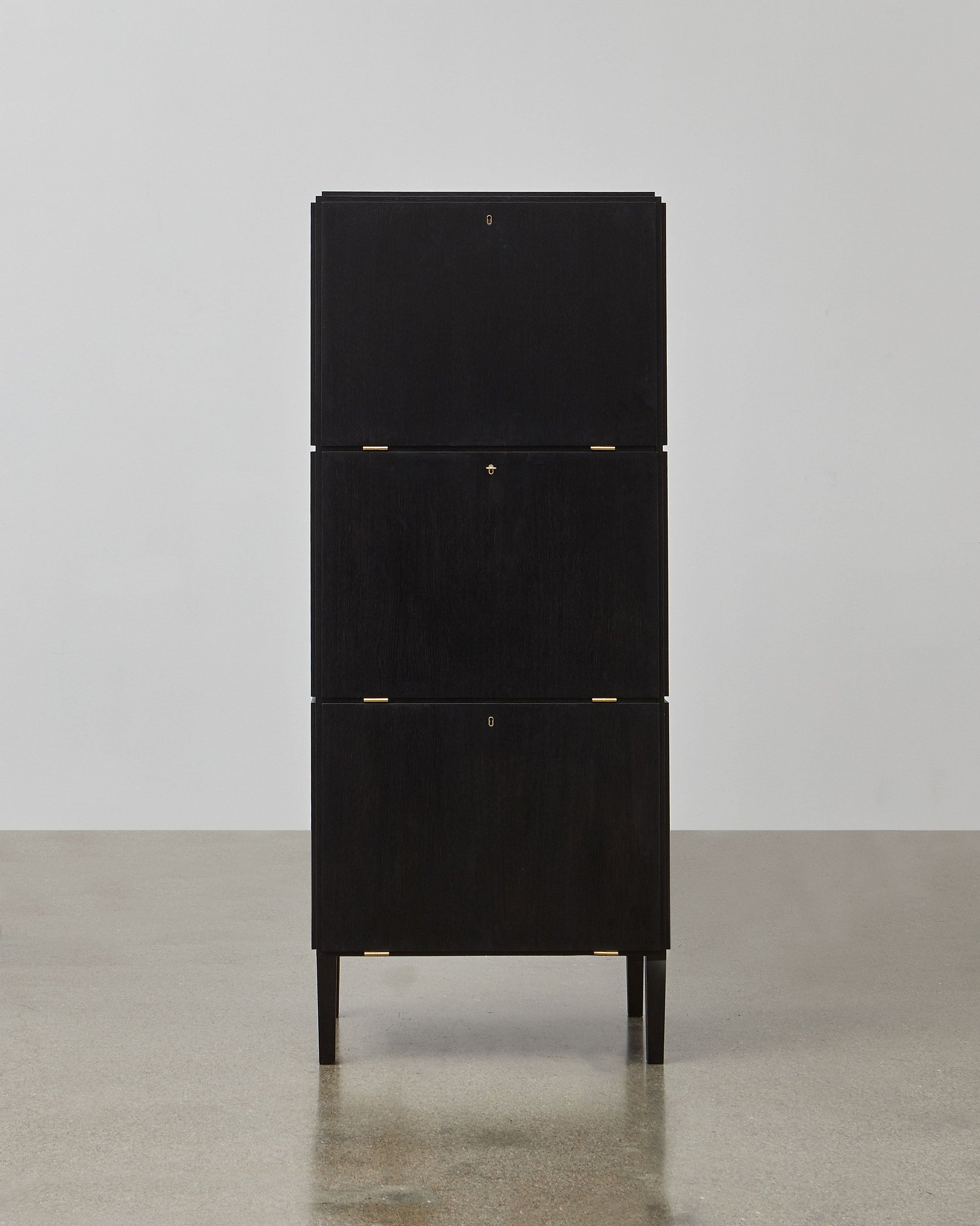 PH Cabinet by Poul Henningsen, Danish design classic (1930s)
A black wooden storage cabinet with three concealed compartments and gold-colored accents.